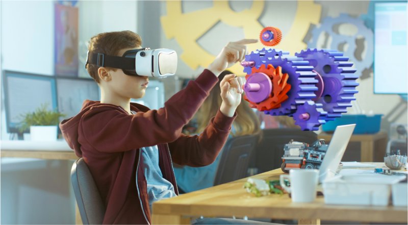 Child using a VR headset to interact with virtual 3D gears, illustrating immersive digital learning.
